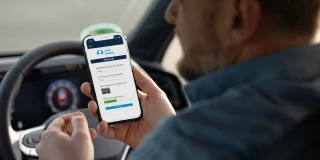 Driver using a smartphone to complete a risk assessment while seated behind the wheel
