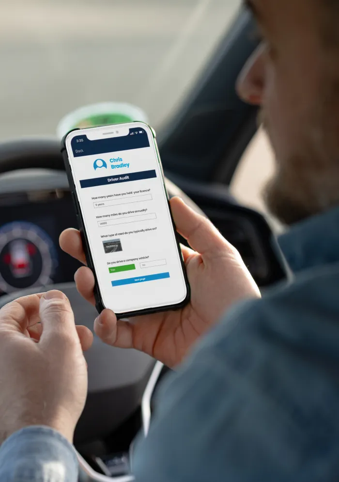 Driver using a smartphone to complete a risk assessment while seated behind the wheel