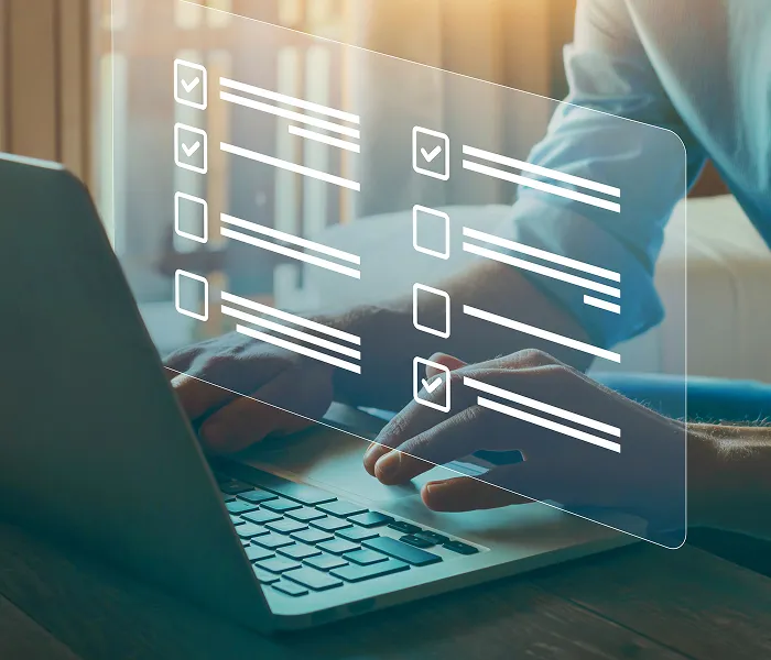 Digital audit checklist displayed over a person working on a laptop
