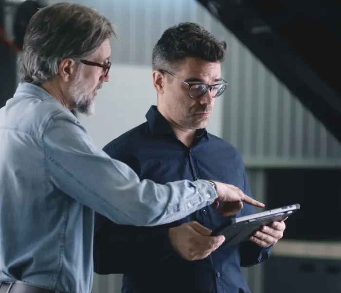 Two colleagues reviewing information together on a tablet