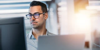 Office worker reviewing information on a computer monitor