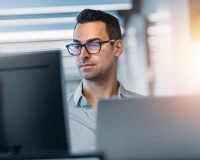 Office worker reviewing information on a computer monitor