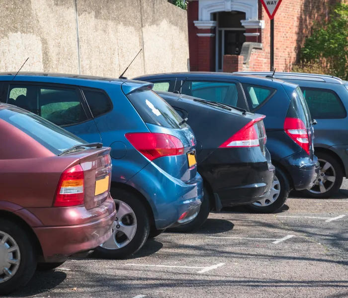 Row of employee-owned vehicles parked in a car park