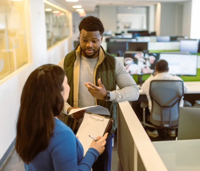 Two colleagues discussing paperwork at an office counter
