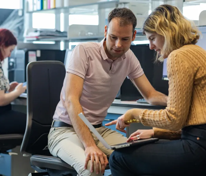 Two colleagues reviewing documents together in an office